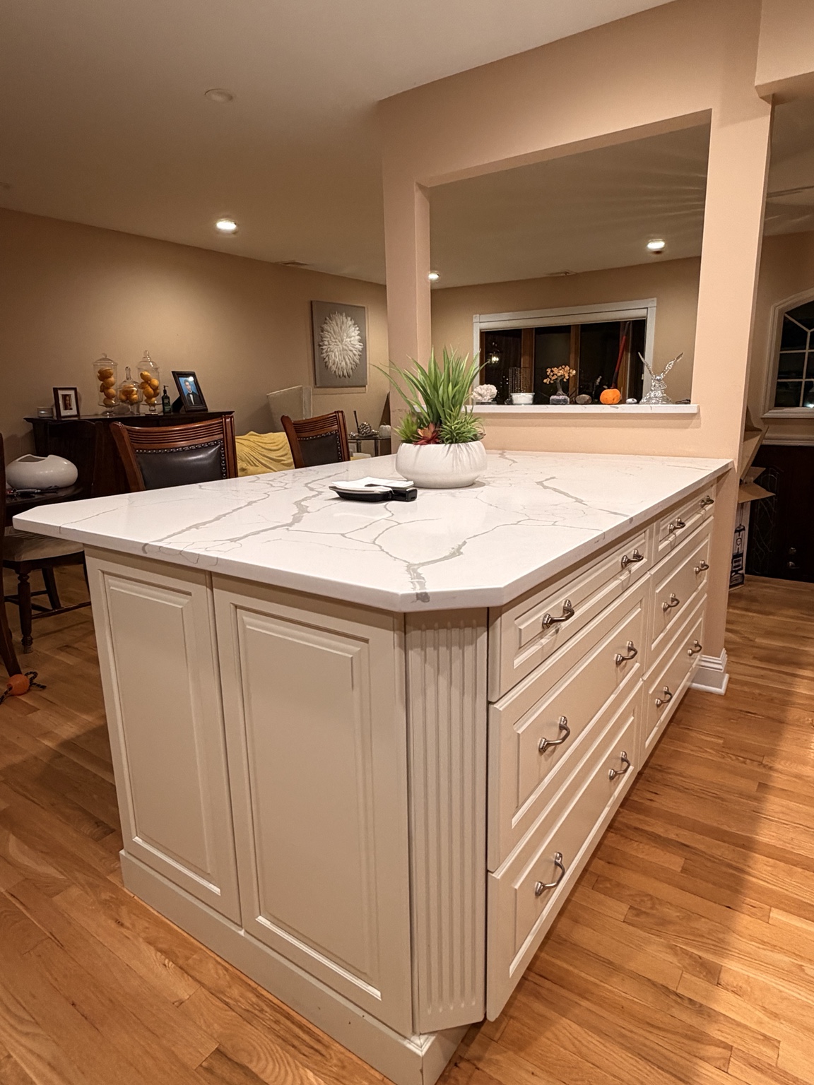 The same kitchen island with a clear countertop and a potted plant after tidying