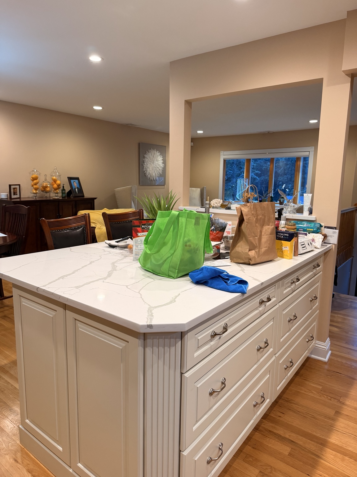 Kitchen island with shopping bags and everyday items across the counter before tidying