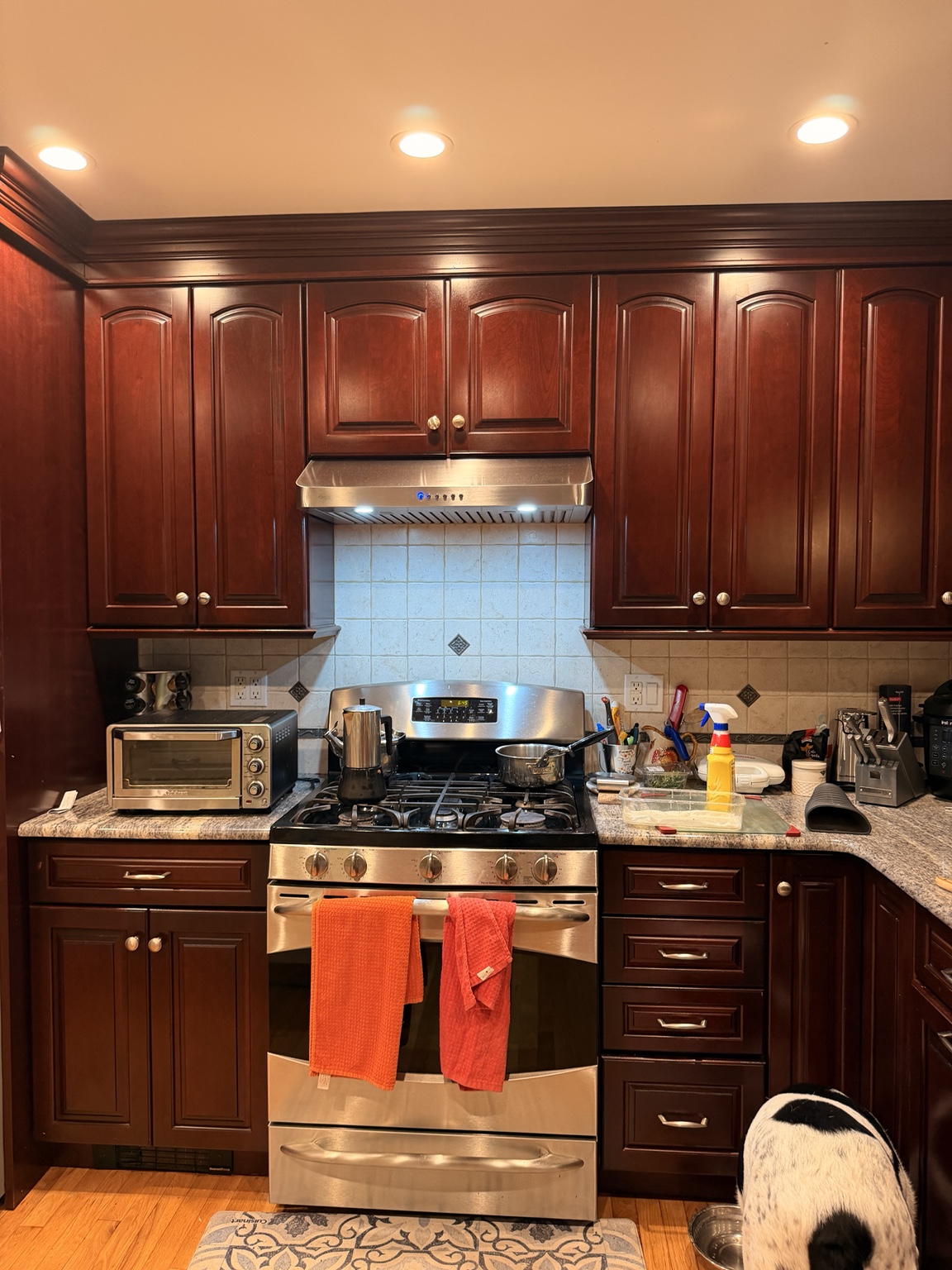 Stove and kitchen counters with cookware and items on the work surfaces before the reset
